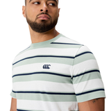 A man wearing the Canterbury Fundamental Yarn Dye Stripe T-Shirt, featuring light green and white stripes and a chest logo, looks to the side.