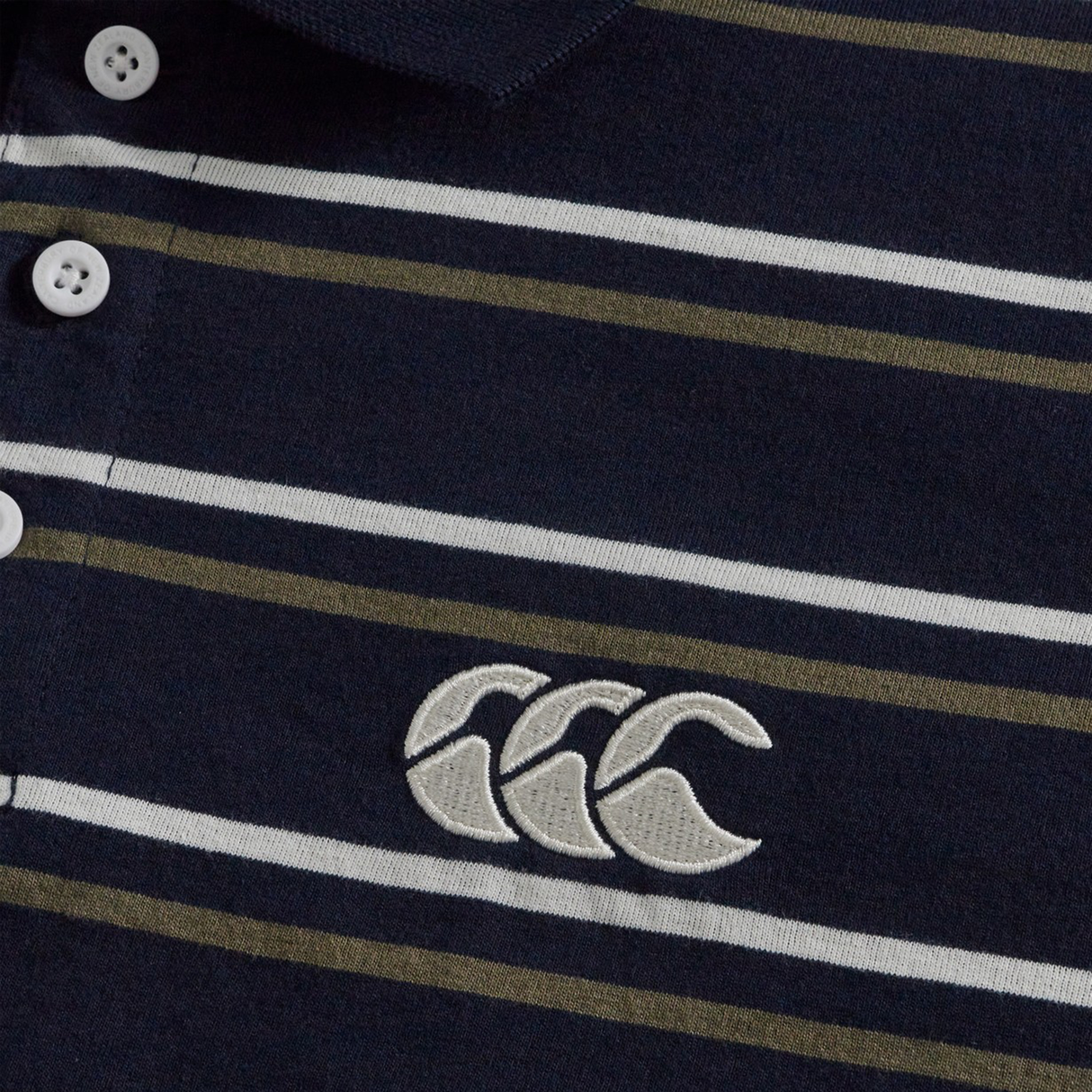 Close-up of the Fundamental Yarn Dye Stripe Polo by Canterbury in navy, with white buttons, horizontal white and olive stripes, and a white embroidered Canterbury logo.