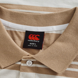 Close-up of the Fundamental Engineered Stripe Polo by Canterbury, featuring beige and white stripes, a classic collar, button detail, and a visible black Canterbury brand tag indicating size L and made in China.