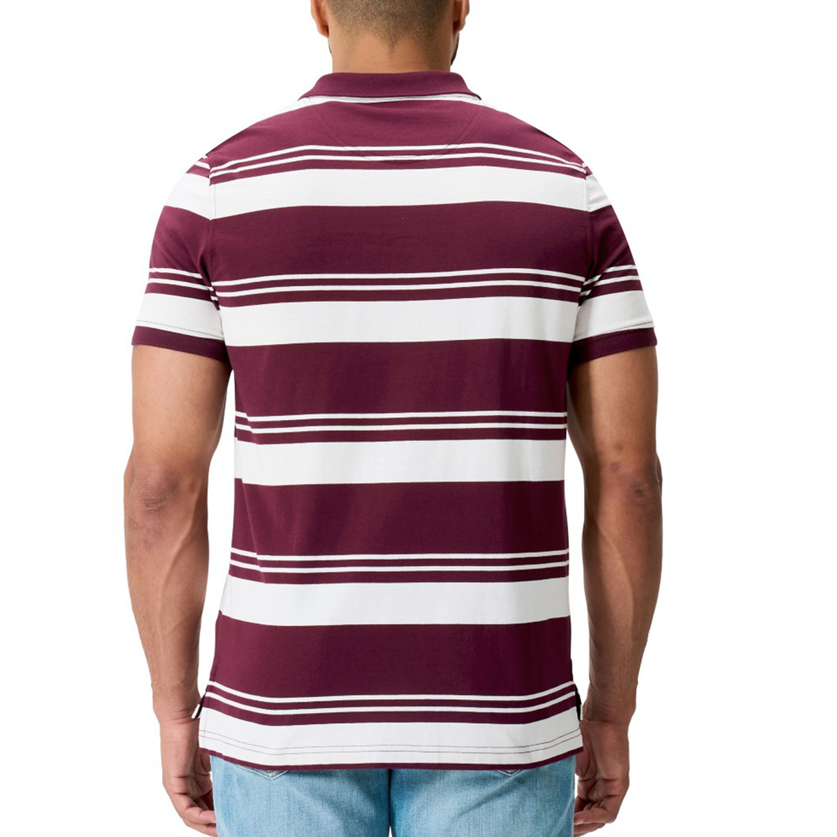 A man is seen from behind wearing the Canterbury Fundamental Engineered Stripe Polo in maroon and white, paired with light blue jeans.