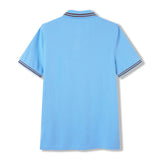 Canterbury Solid Dye Polo by Canterbury in sky blue, featuring short sleeves and dark and white striped trim on the collar and sleeve cuffs, shown from the back.