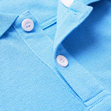 A close-up of the Canterbury Solid Dye Polo by Canterbury in light blue showcases its textured fabric, two white buttons, and a portion of the collar.