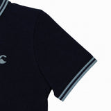 Close-up of the Canterbury Solid Dye Polo by Canterbury, a rugby-inspired navy blue short-sleeve polo shirt featuring light blue trim on the sleeves and collar, with a small embroidered chest logo for an athletic look.