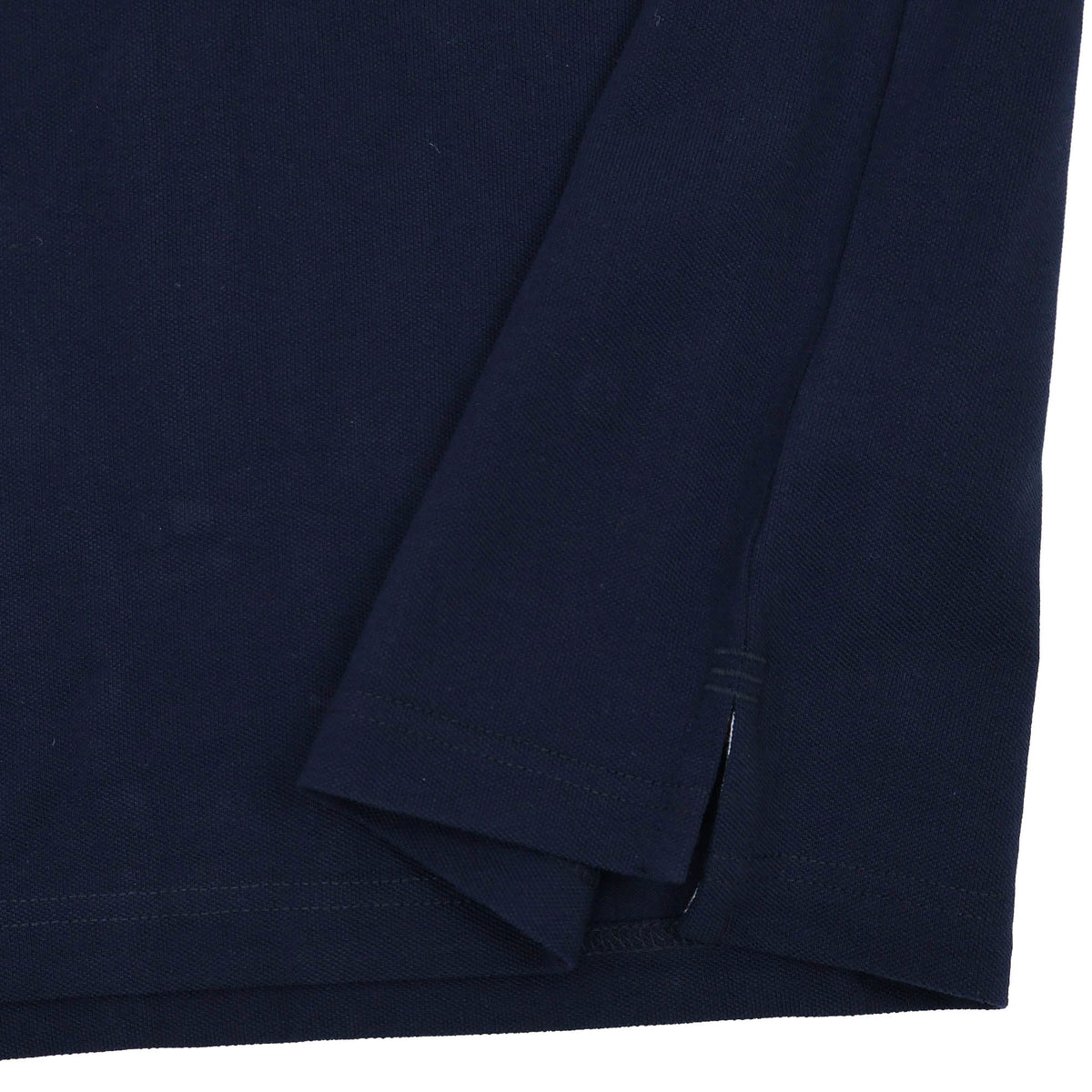 Close-up of the hem and side slit of the Canterbury Solid Dye Polo by Canterbury, in dark navy, showcasing folded fabric and visible stitching inspired by classic rugby style.