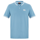 The Fundamental Solid Dye Polo by Canterbury features a light blue solid dye, white collar and sleeve stripes, three-button placket, and a white logo on the left chest for a classic rugby-inspired style.