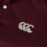 Close-up of the Canterbury Fundamental Solid Dye Polo in maroon, featuring two white buttons and a white embroidered Canterbury logo on the chest, highlighting its rugby-inspired style.