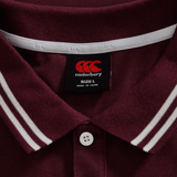 Close-up of the Canterbury Fundamental Solid Dye Polo in maroon, featuring white-striped collar, rugby-inspired design, and a visible tag showing size L and made in China.