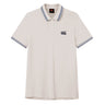 The Canterbury Solid Dye Polo by Canterbury is a white short-sleeve athletic shirt featuring a blue-striped collar and cuffs, a two-button placket, and a small black logo on the left chest.