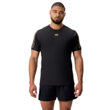 A man wearing the Canterbury Tempo+ Drill Top and matching black shorts stands facing forward against a plain white background.