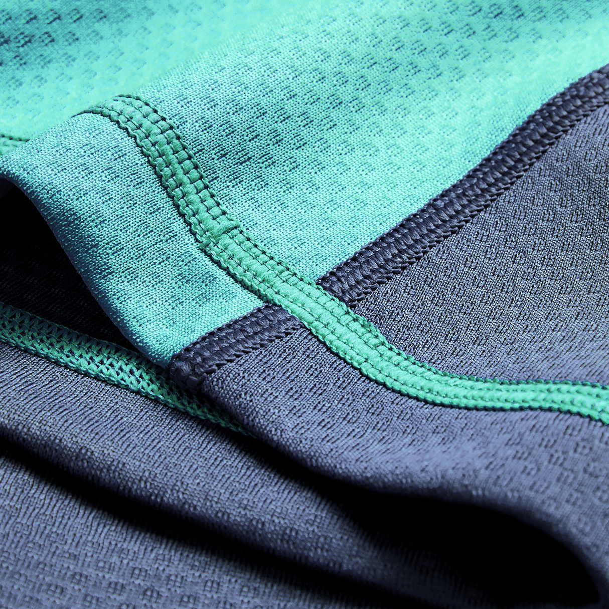 Close-up of turquoise and dark gray athletic fabric with visible stitching, from the Ireland 26/27 Summer Tour "Baltic" Training Test Jersey by Canterbury.