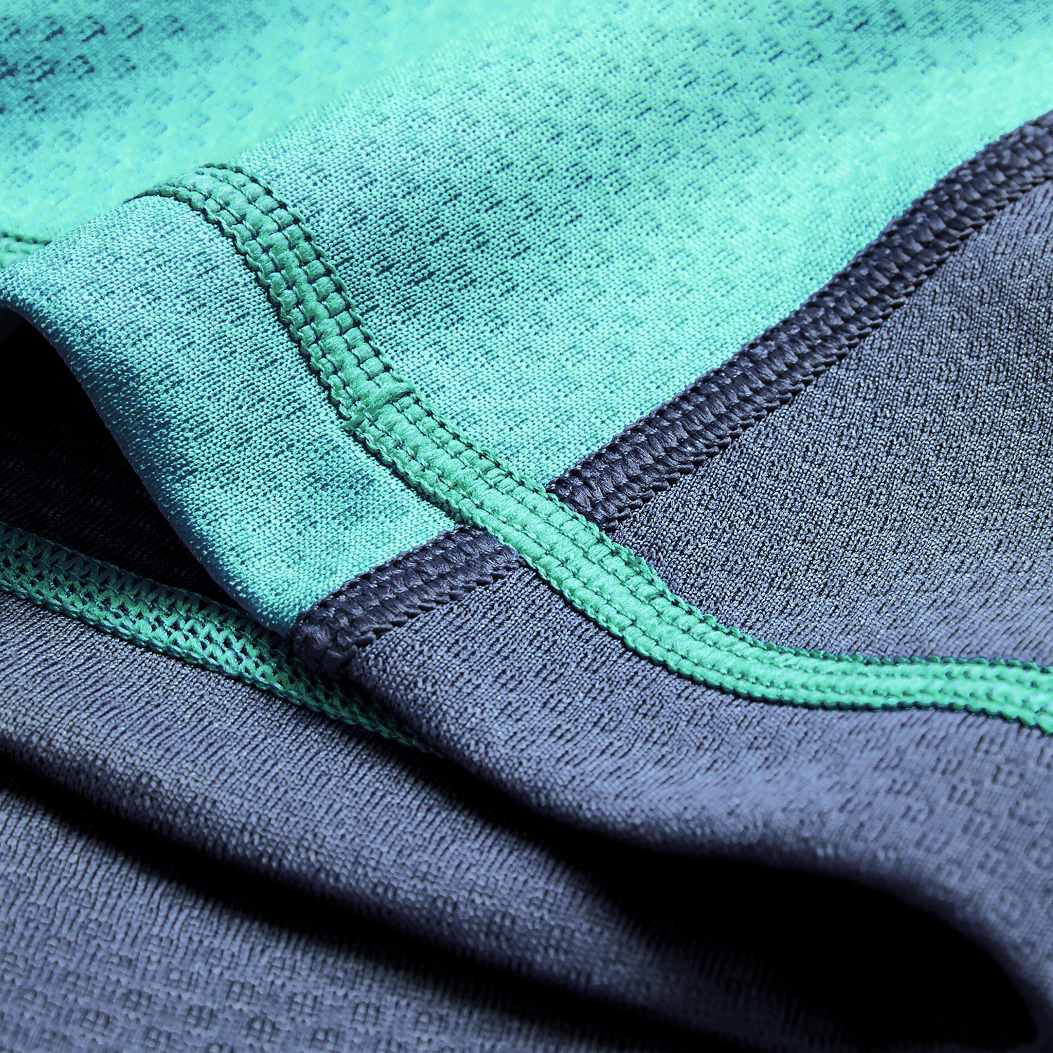 Close-up of turquoise and dark gray athletic fabric with visible stitching, from the Ireland 26/27 Summer Tour "Baltic" Training Test Jersey by Canterbury.