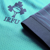 Close-up of the Ireland 26/27 Summer Tour "Baltic" Training Test Jersey by Canterbury in teal, featuring the IRFU shamrock logo and blue-green sleeve stripes—ideal for fans supporting Ireland on their summer tour.