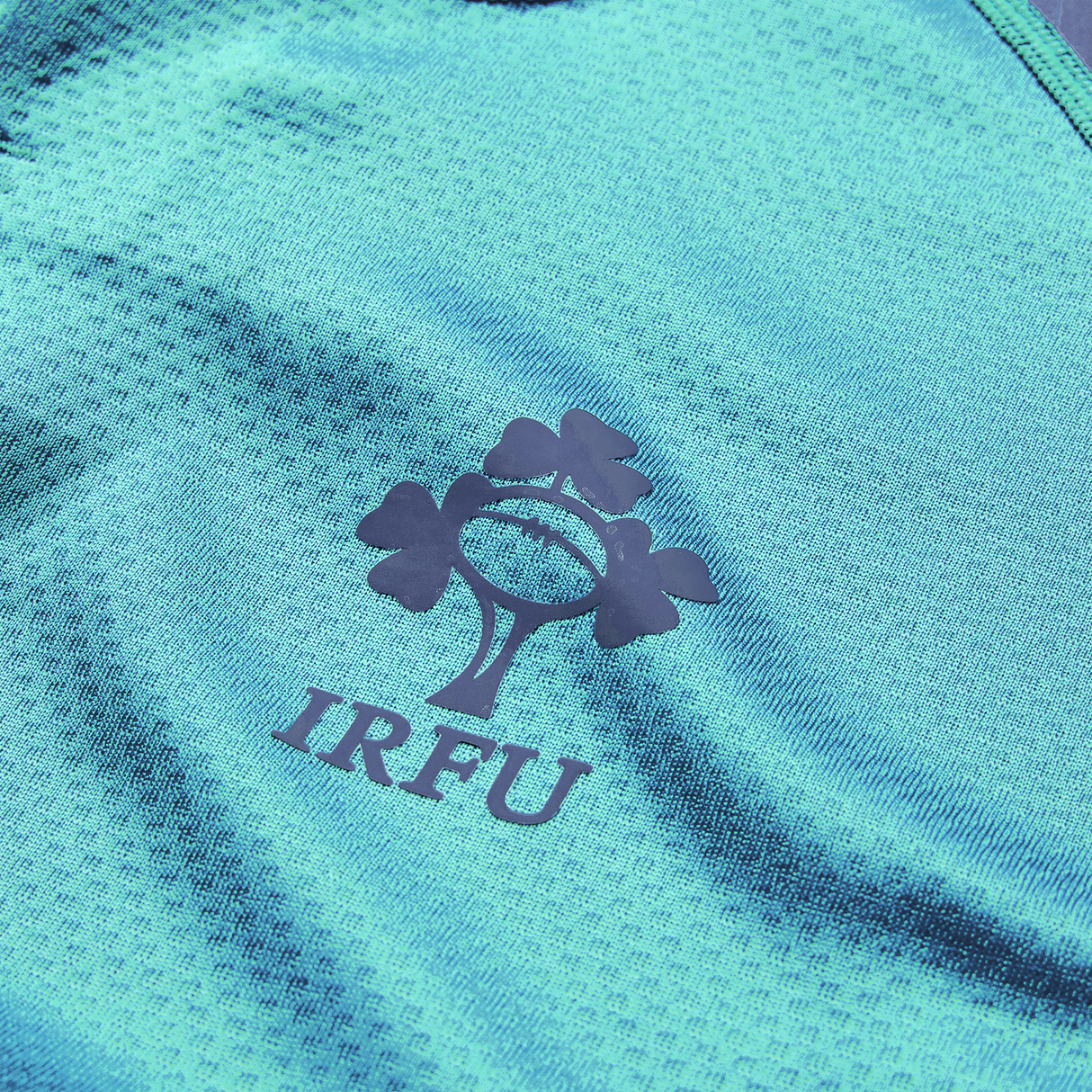Close-up of the Ireland 26/27 Summer Tour "Baltic" Training Test Jersey by Canterbury, featuring the IRFU logo with a rugby ball and three shamrocks—ideal for showing support during the summer tour.