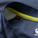 Close-up of the Ireland 26/27 Summer Tour "Indigo" Training Test Jersey by Canterbury—navy blue textured fabric, yellow inner collar, visible stitching, and red logo tag for the perfect Summer Tour Test Fit.