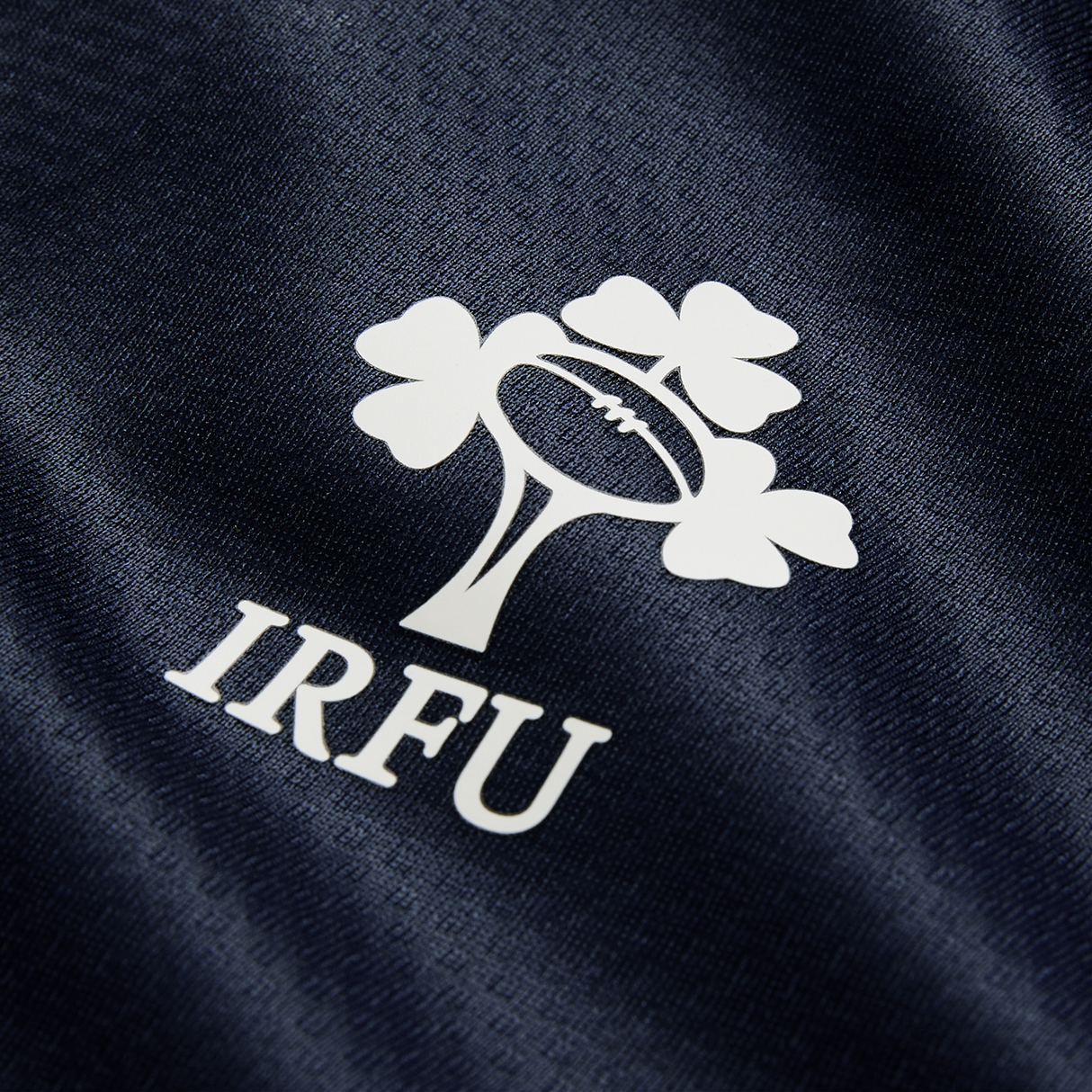 Close-up of the IRFU logo with rugby ball and shamrock on Canterbury’s Ireland 26/27 Summer Tour "Indigo" Training Test Jersey, part of the latest collection.