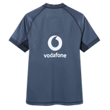 Back view of the Ireland 26/27 Summer Tour "Indigo" Training Test Jersey by Canterbury in navy blue, featuring a white Vodafone logo and abstract dark sleeve patterns, designed for IRFU by Canterbury.