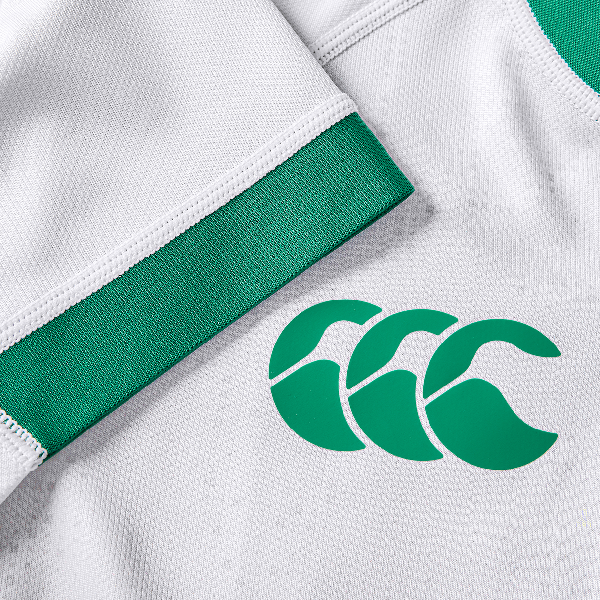 Close-up of the Women's Ireland 25/26 Alternate Pro Jersey by Canterbury: a white pro jersey with green trim and Canterbury's logo featuring three stylized "C" shapes, printed on the fabric.