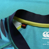 Close-up of the neckline of the Ireland 26 Pre Game Pro Jersey by Canterbury featuring visible Canterbury logos, lime green trim, and textured, moisture-wicking fabric.