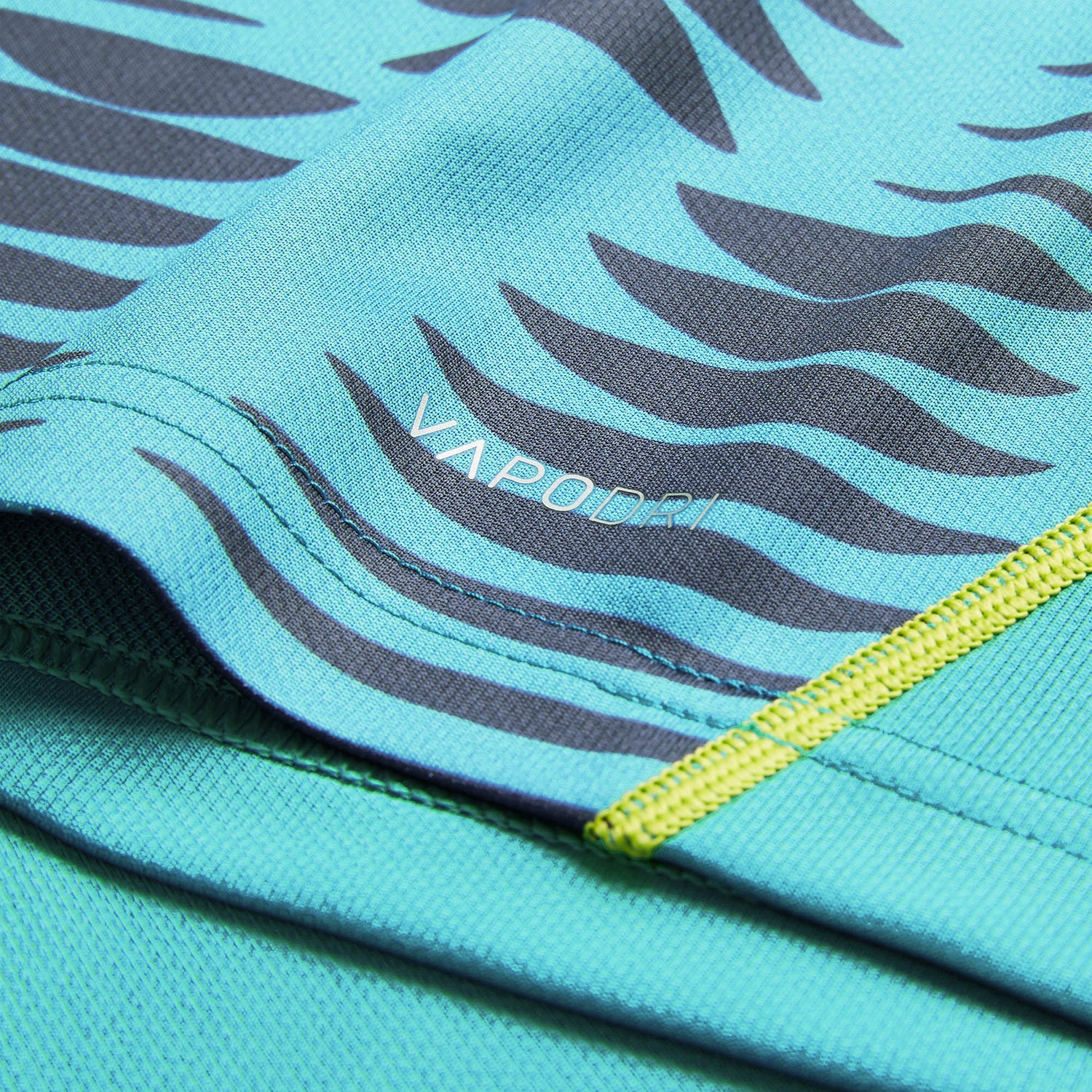 Close-up of the Ireland 26 Pre Game Pro Jersey by Canterbury, featuring a turquoise moisture-wicking fabric with wavy black stripes and visible stitching. The word “VAPODRI” is printed in white on the surface, highlighting the advanced technology that sets Canterbury jerseys apart.