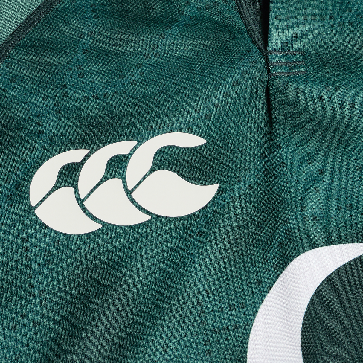 Close-up of the Ireland 25/26 Six Nations Pro Training Jersey by Canterbury, showcasing a white triple-curved Canterbury logo on textured green fabric with advanced Vapodri technology.