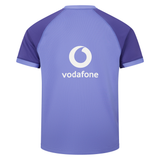 The Ireland 25/26 Six Nations Pro Training Jersey by Canterbury features short sleeves, dark purple accents, a white "vodafone" logo on the back, and is made from Vapodri fabric for comfort.