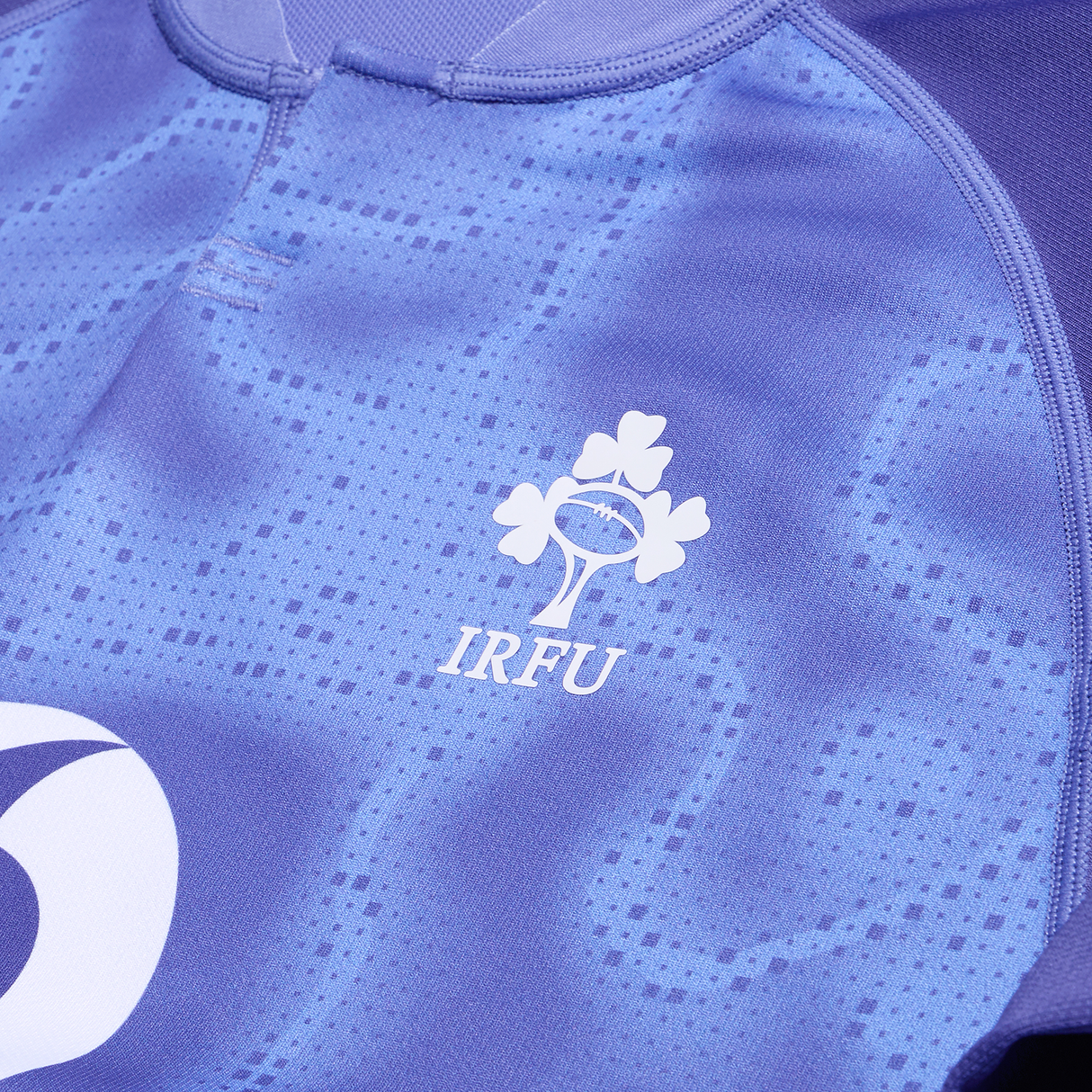 Close-up of the Ireland 25/26 Six Nations Pro Training Jersey by Canterbury, showcasing the IRFU logo with a rugby ball and three shamrocks, made from Canterbury Vapodri fabric.