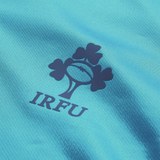 Close-up of the Ireland 26/27 Summer Tour Training Pro Jersey by Canterbury, a blue training top featuring the Irish Rugby Football Union (IRFU) logo with a rugby ball and three shamrocks.