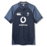 The Ireland 26 Training Pro Jersey by Canterbury is a navy blue rugby top with short sleeves, Vodafone sponsor, and IRFU chest logo, featuring patterned shoulder panels. Displayed on a white background, this Canterbury jersey is crafted with innovative VapoDri fabric for superior comfort and performance.