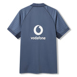 Back view of the Canterbury Ireland 26 Training Pro Jersey, a short-sleeve dark blue rugby jersey showcasing subtle geometric patterns on the shoulders and a prominent Vodafone logo. Crafted in Canterbury’s signature Training Jersey style, it features advanced VapoDri technology for enhanced comfort.