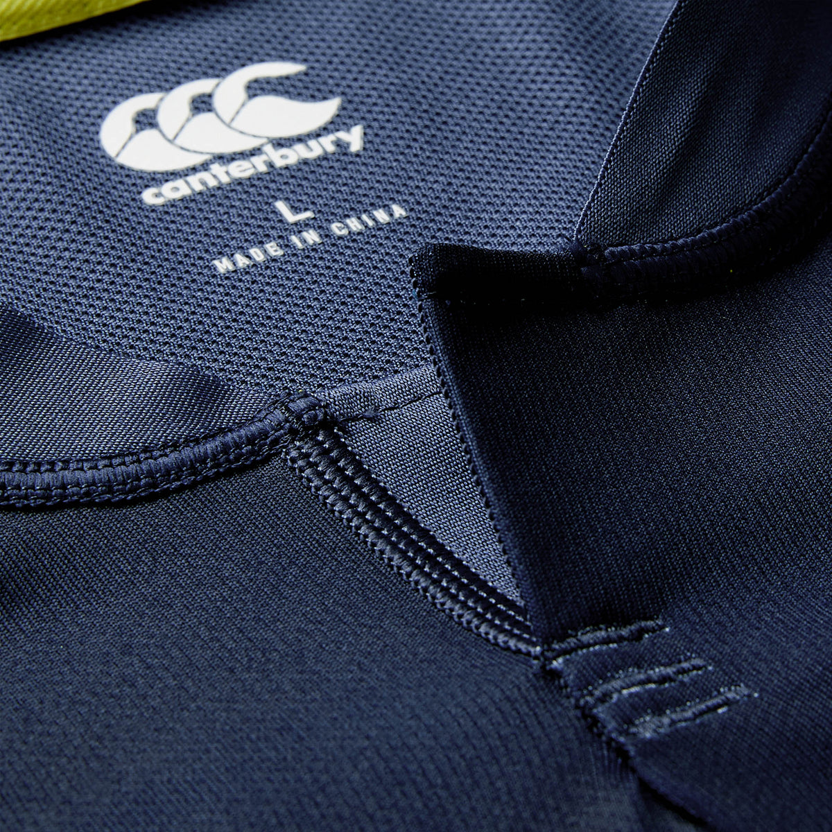 Close-up of the Ireland 26 Training Pro Jersey by Canterbury in blue, featuring the Canterbury brand logo, size label, “Made in China” text, and intricate stitching details near the collar and neckline, echoing the design of an authentic Ireland Rugby shirt.