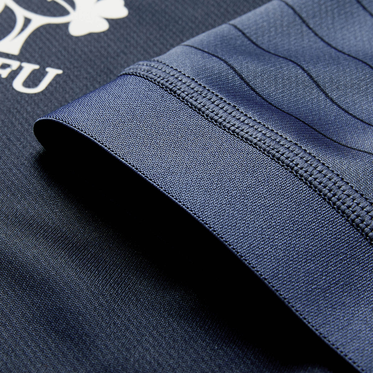 Close-up of a navy blue Ireland 26 Training Pro Jersey by Canterbury sleeve, showing visible stitching and part of the white Canterbury logo and text on the fabric, featuring VapoDri technology.