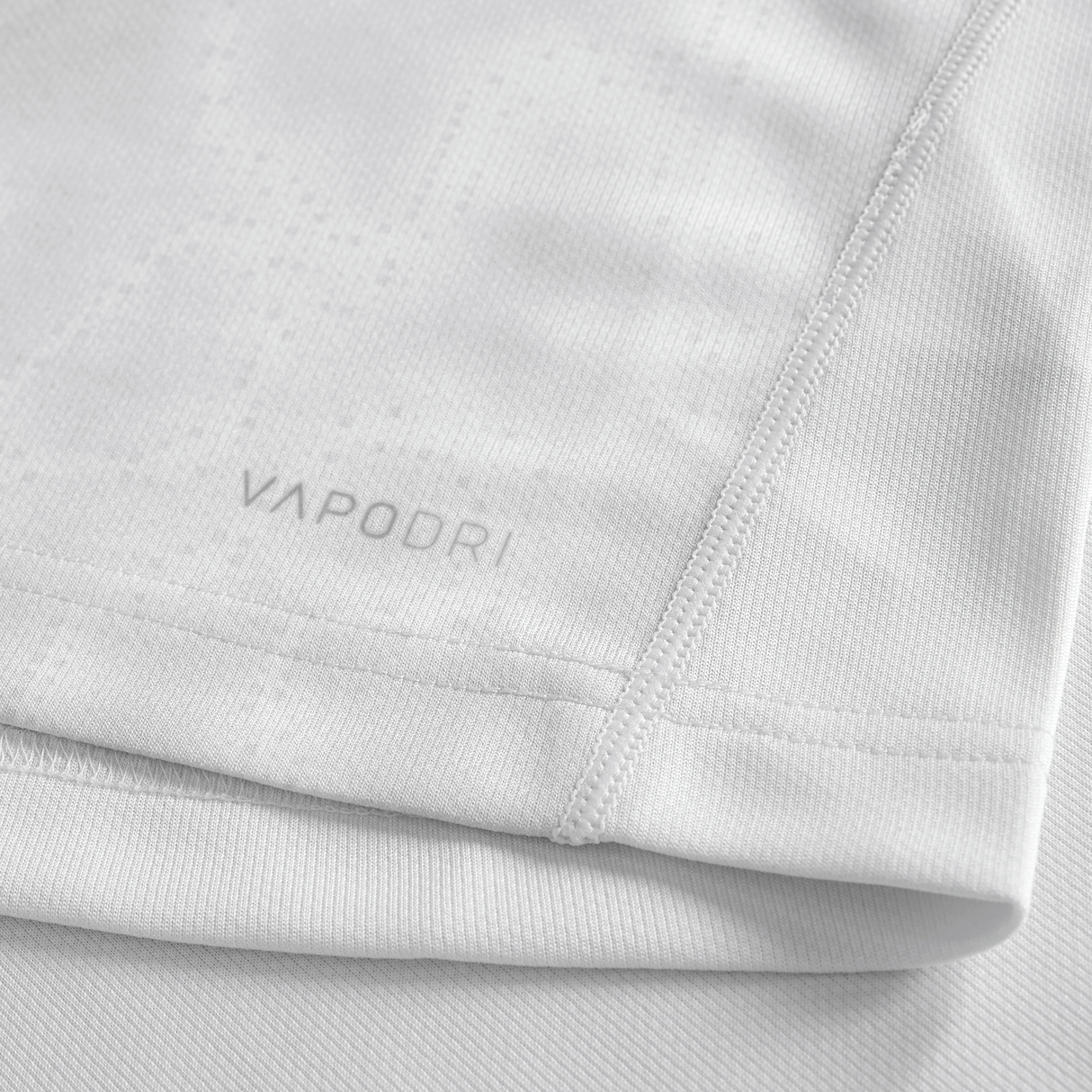 Close-up of the Youth Ireland 25/26 Alternate Pro Jersey by Canterbury in light grey, showing "VAPODRI" near the hem, detailed stitching, and textured fabric—an ideal pick for young rugby fans.
