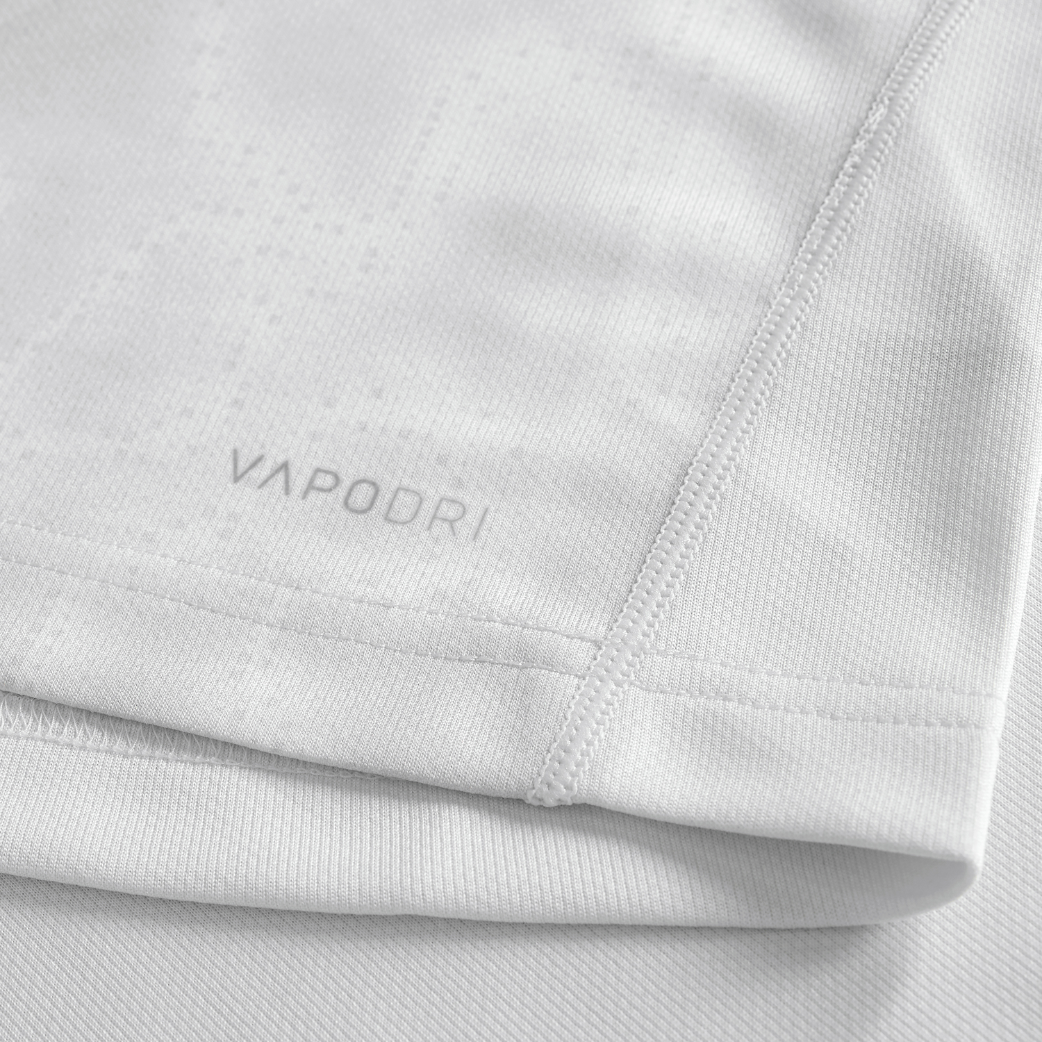 Close-up of the Youth Ireland 25/26 Alternate Pro Jersey by Canterbury in light grey, showing "VAPODRI" near the hem, detailed stitching, and textured fabric—an ideal pick for young rugby fans.