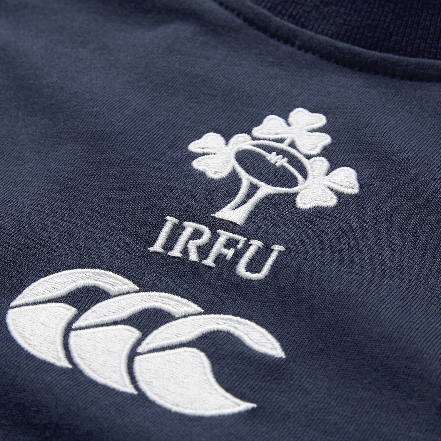 Close-up of the Ireland 26/27 Summer Tour Team Cotton T-Shirt by Canterbury in navy, showcasing the embroidered IRFU shamrock and white Canterbury logo—ideal for supporting Ireland this summer.