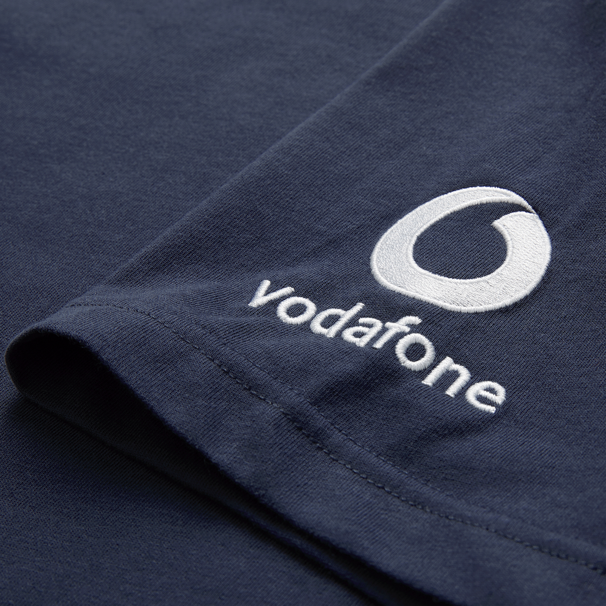 Close-up of the Ireland 26/27 Summer Tour Team Cotton T-Shirt by Canterbury in navy blue, with the Vodafone logo and name embroidered in white on the sleeve—ideal for supporting Ireland this summer.