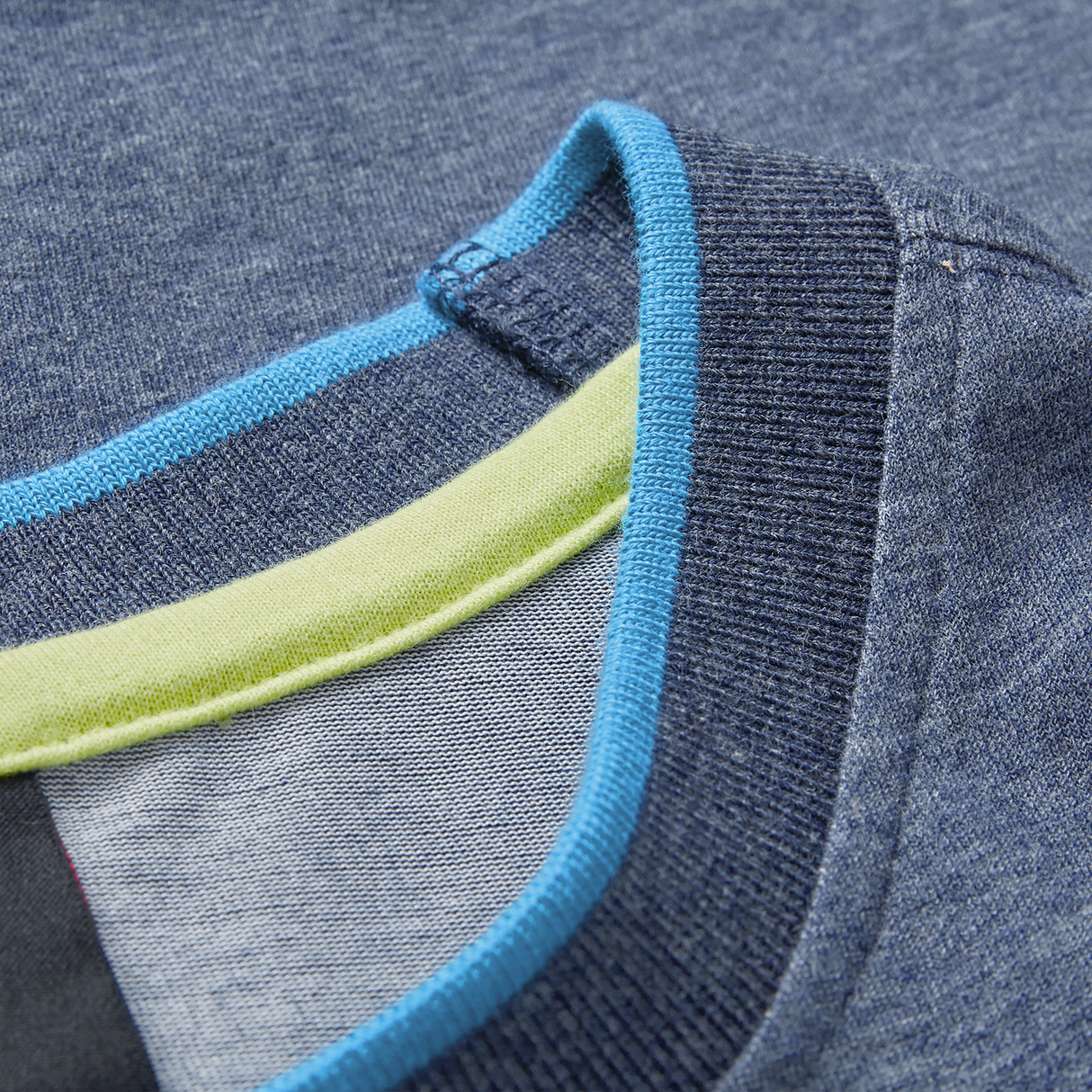Close-up of the Ireland 26/27 Summer Tour Team Cotton T-Shirt by Canterbury, featuring a blue collar with ribbed navy trim and light blue and green accents inside—an ideal choice for your summer tour.