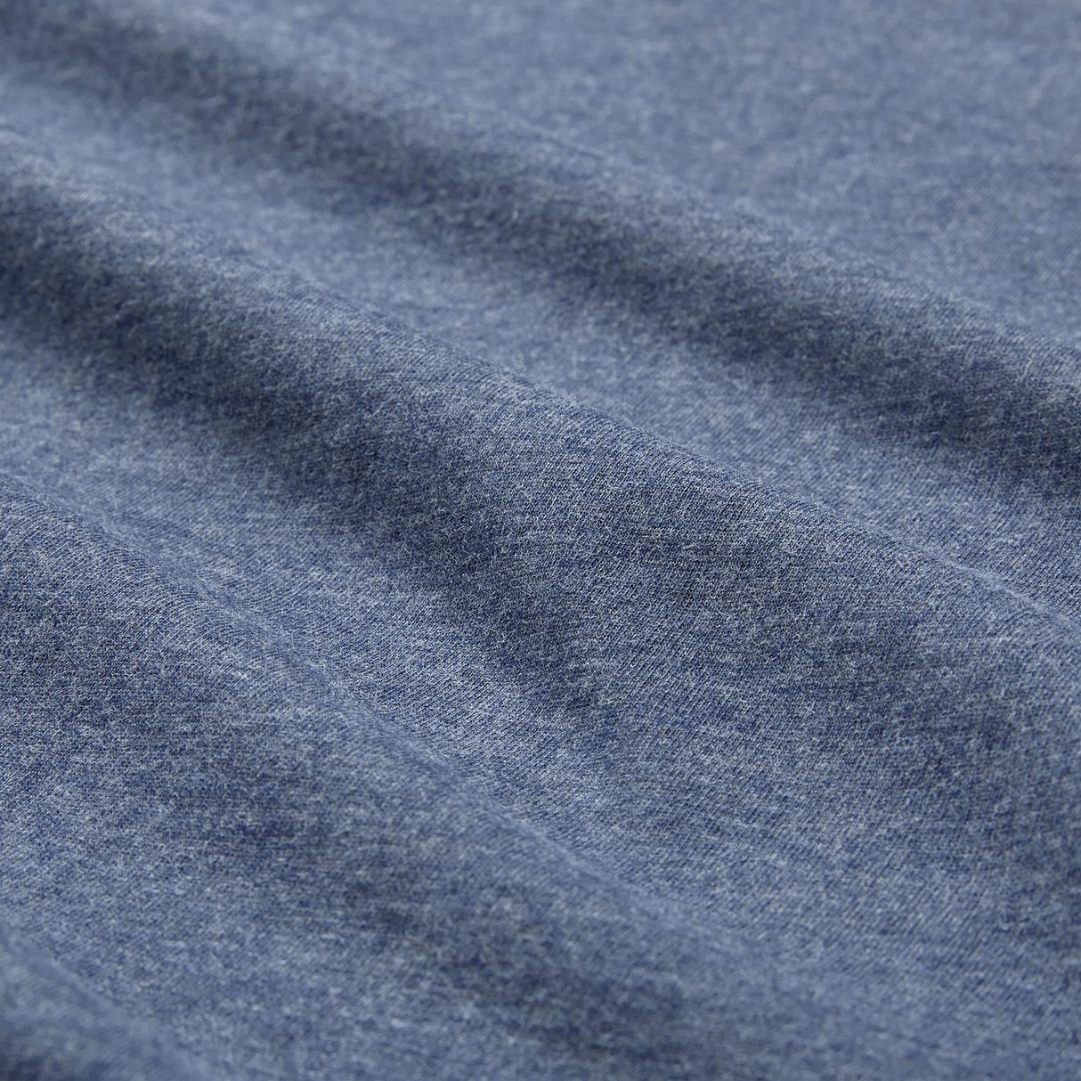 Close-up of blue heather fabric from the Ireland 26/27 Summer Tour Team Cotton T-Shirt by Canterbury, highlighting its texture and gentle horizontal folds—ideal for the season's rugby excitement.