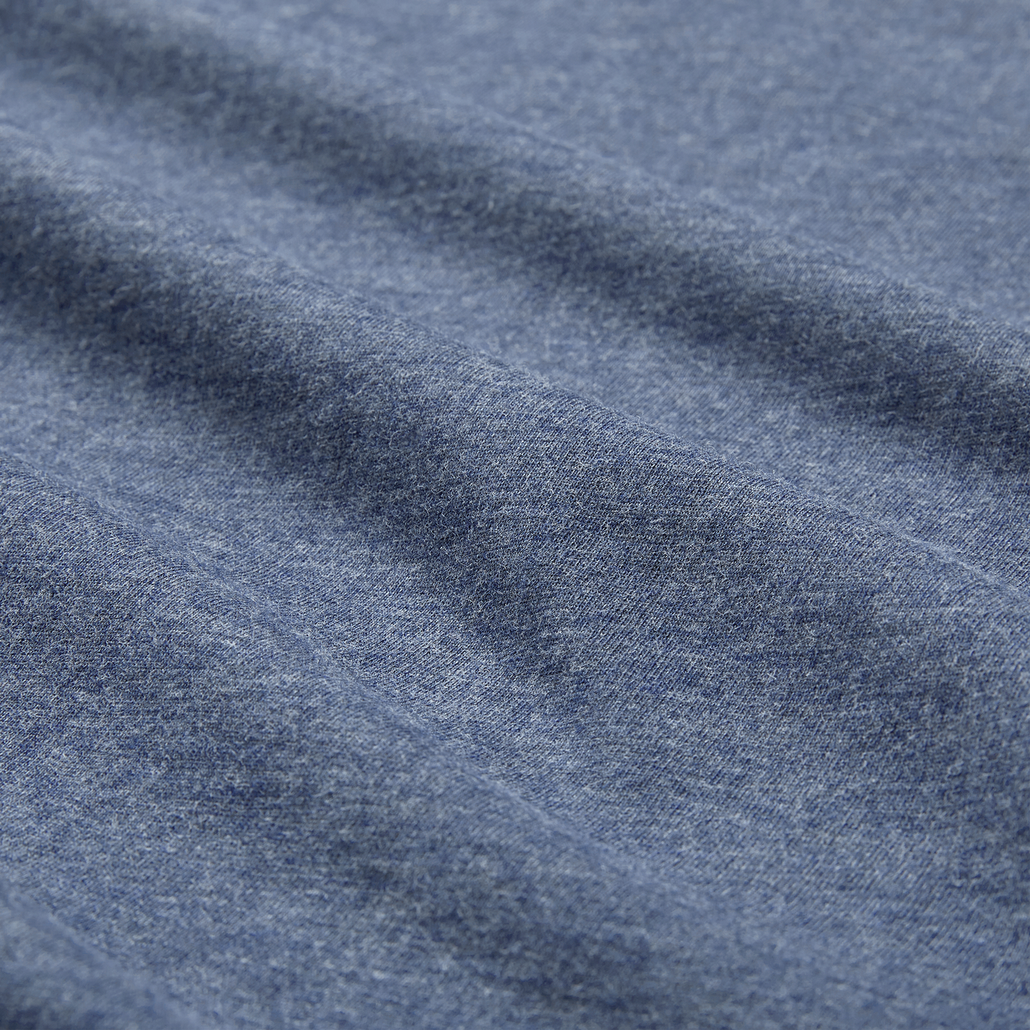 Close-up of blue heather fabric from the Ireland 26/27 Summer Tour Team Cotton T-Shirt by Canterbury, highlighting its texture and gentle horizontal folds—ideal for the season's rugby excitement.