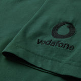 Close-up of the green fabric from the Ireland 26 Team Cotton T-shirt by Canterbury, featuring the Vodafone logo and name embroidered in black on the sleeve.