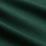 Close-up of dark green fabric with a visible soft texture and gentle horizontal folds, reminiscent of the premium material used in the Ireland 26 Team Cotton T-shirt by Canterbury.