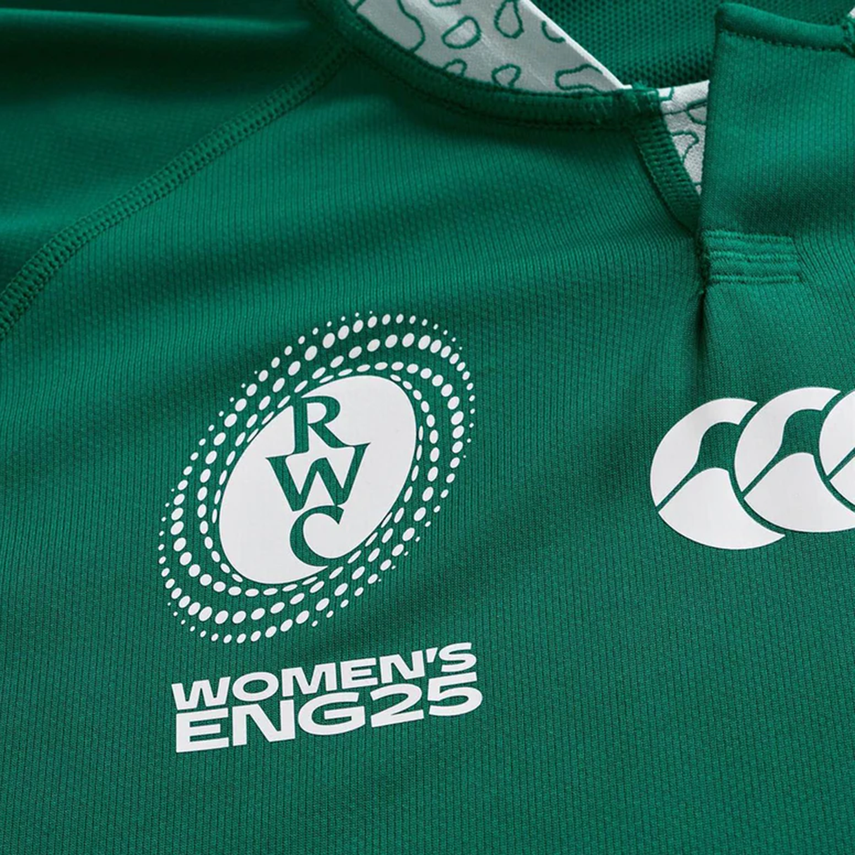 Close-up of the Ireland WRWC25 Replica Home Jersey by Canterbury, a green rugby jersey with the Rugby World Cup and Canterbury logos, plus "WOMEN'S ENG25" text.