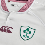 A close-up of the Ireland WRWC25 Replica Alternate Jersey by Canterbury highlights the Canterbury logo, IRFU crest with shamrock and ball, and a pink-patterned collar—making it a standout rugby jersey for World Cup 2025.