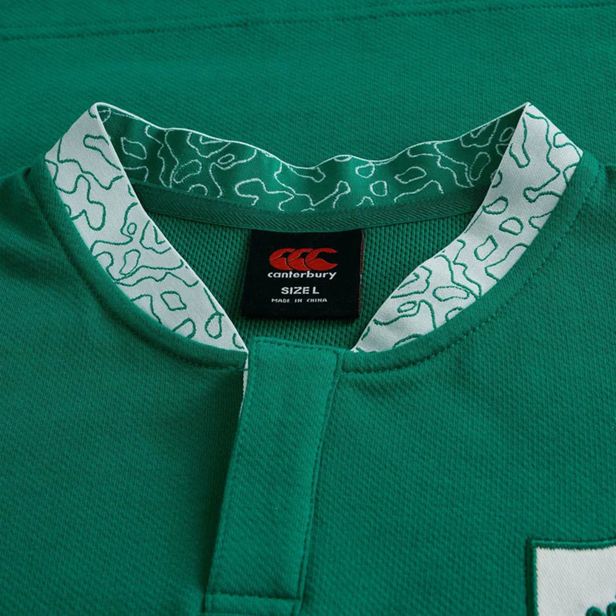 Close-up of the Ireland WRWC25 Classic Jersey by Canterbury, highlighting the green collar with a white and green pattern, brand label, and size L tag.