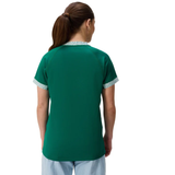 A woman with brown hair in a ponytail wears the Canterbury Women's Ireland WRWC25 Replica Home Jersey with patterned trim and light blue pants, shown from behind against a white background.
