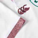 Close-up of the Women's Ireland WRWC25 Replica Alternate Jersey by Canterbury, showing a maroon logo, a patterned pink tag, and part of an embroidered green and white badge.