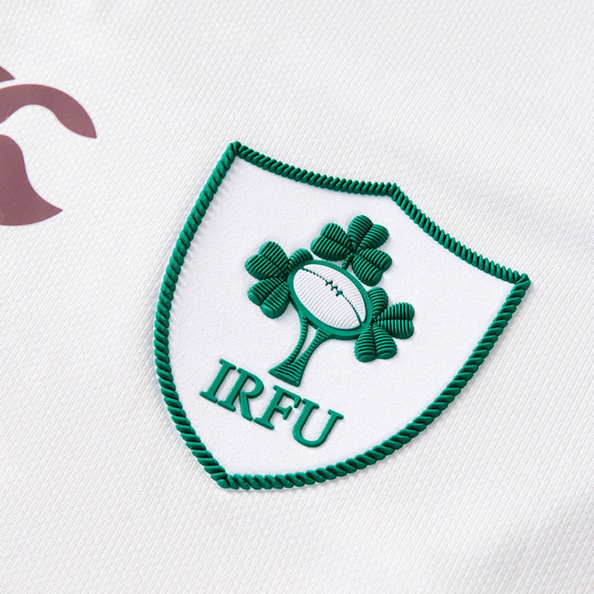 Close-up of the Canterbury Women's Ireland WRWC25 Replica Alternate Jersey, showing the IRFU logo with a green shamrock and rugby ball on white fabric, designed for the Ireland Women’s Rugby World Cup 2025 team.