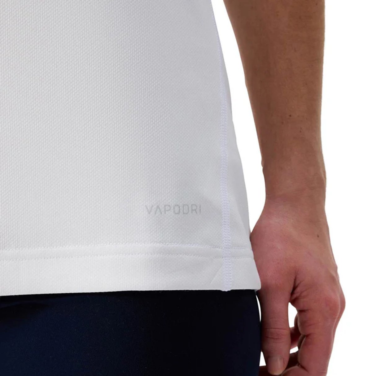 A close-up of a person’s hand resting by their side, wearing the Canterbury Women's Ireland WRWC25 Replica Alternate Jersey and dark pants.