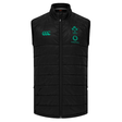 The Ireland 25/26 Elite Gilet by Canterbury is a black sleeveless puffer vest with a front zipper and green IRFU, Vodafone, and Canterbury logos on the chest. This official fan item is part of the Elite Gilet collection.