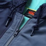 Close-up of the Ireland 26 Legends 1/4 Zip Jacket by Canterbury in navy blue, featuring a hood with drawstrings and Canterbury branding, layered over a green shirt—a modern tribute to the classic Ireland Rugby style.