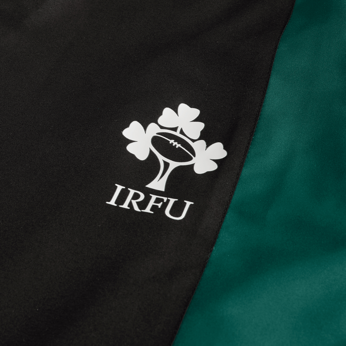 Close-up of a jersey with the IRFU logo beside the Ireland Legends Track Pant by Canterbury, set against a black and green background that celebrates rugby culture.